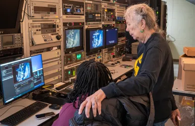 Wendy Clarke and Mare Lodu look at a bank of monitors while digitizing a tape